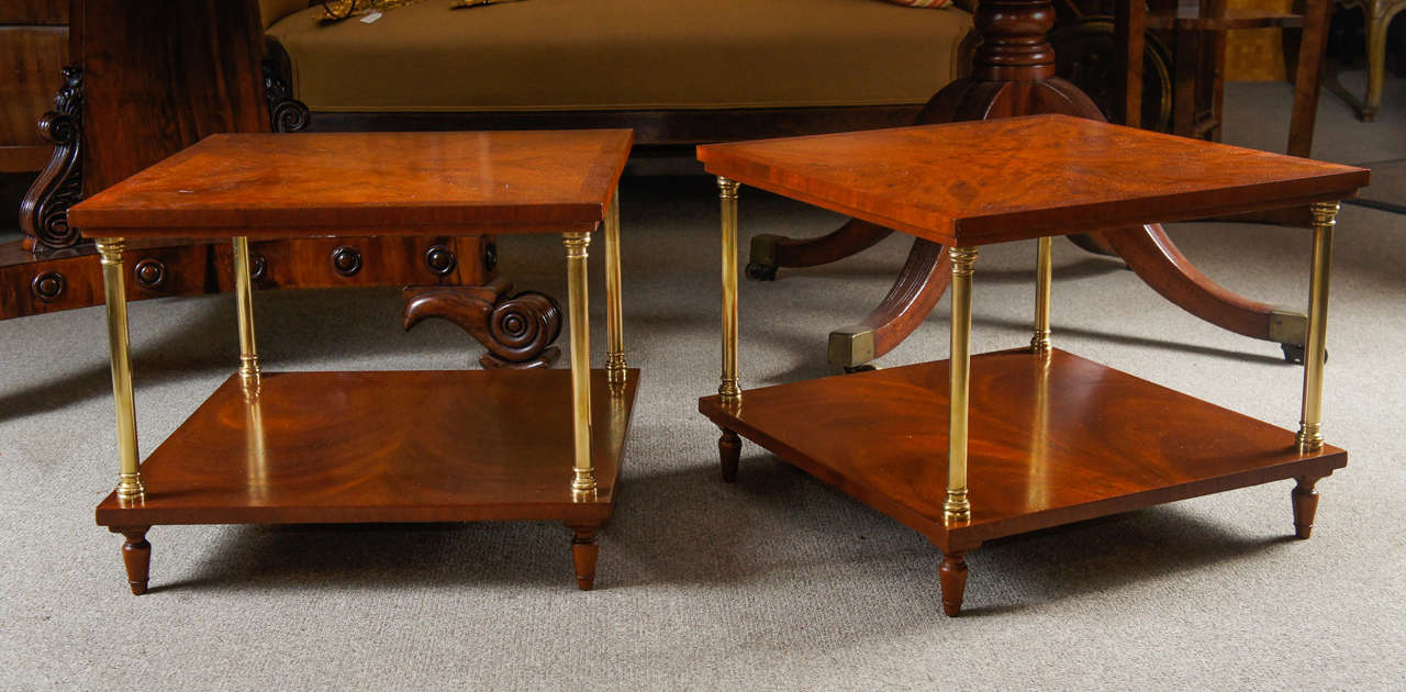 Pair of two tier yew wood side tables with brass supports.