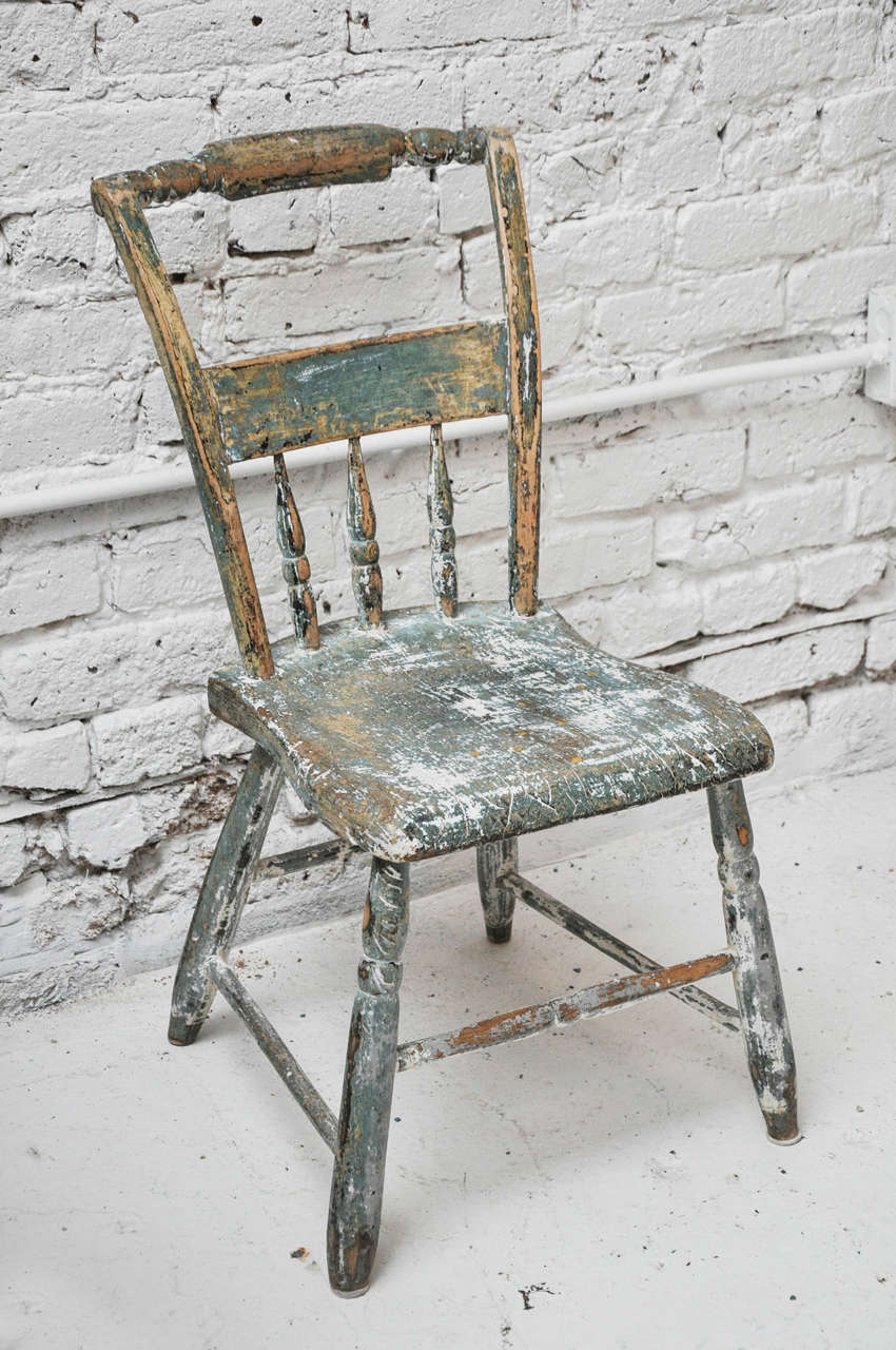 Small in size, big in beauty! This antique chair is done in a beautiful rubbed through green finish and has a nicely detailed carved back.