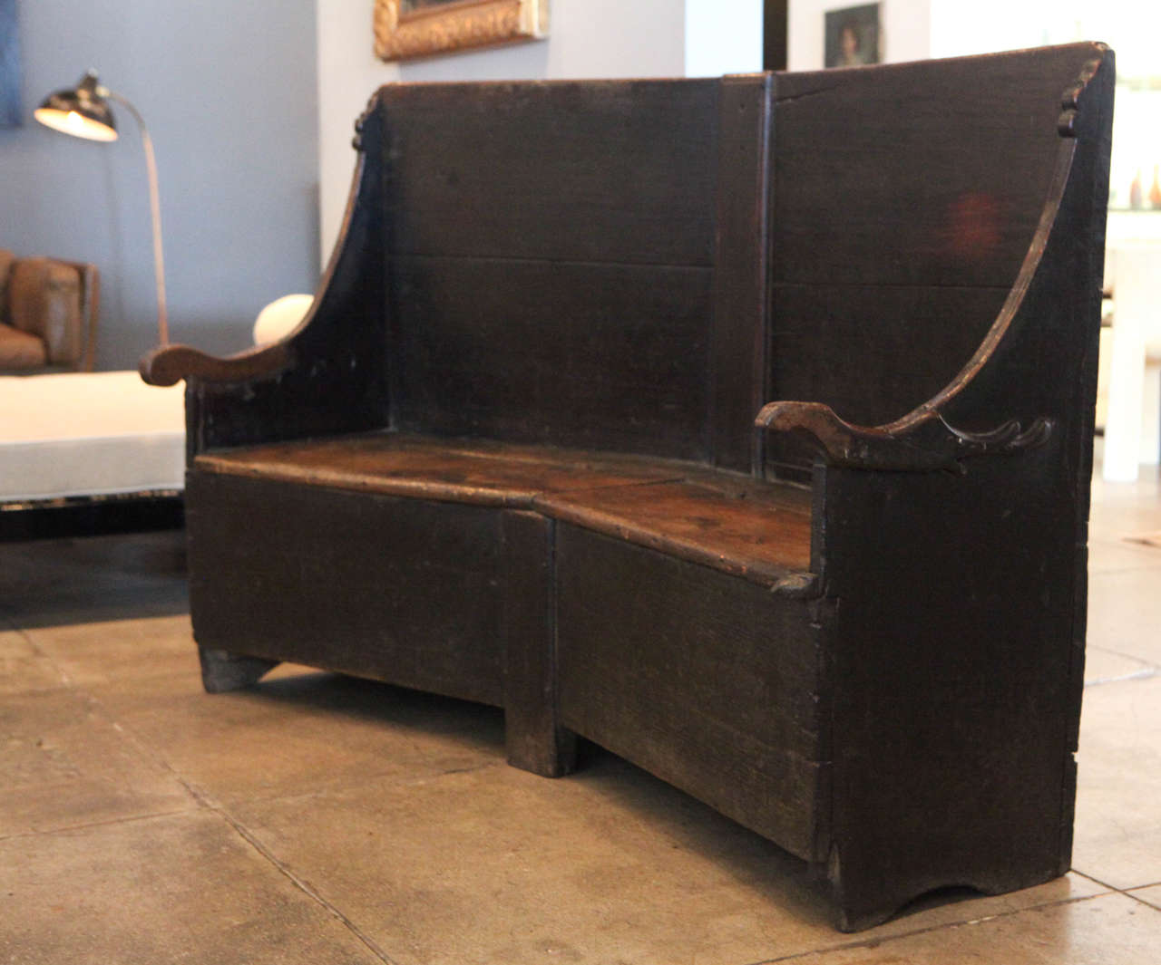 A beautiful ebonized walnut bench from the early 18th century with storage under each seat.