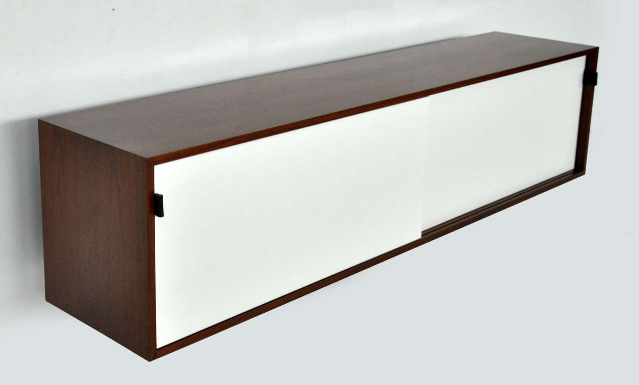 Wall mount credenza designed by Florence Knoll. Walnut case with leather pulls.   Fully restored.