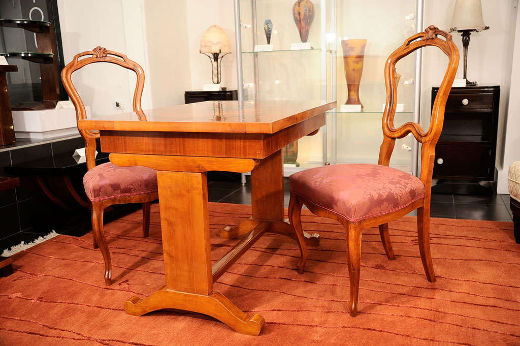 Table de jeu Biedermeier et deux chaises en noyer, bois de racine et bois ébonisé.