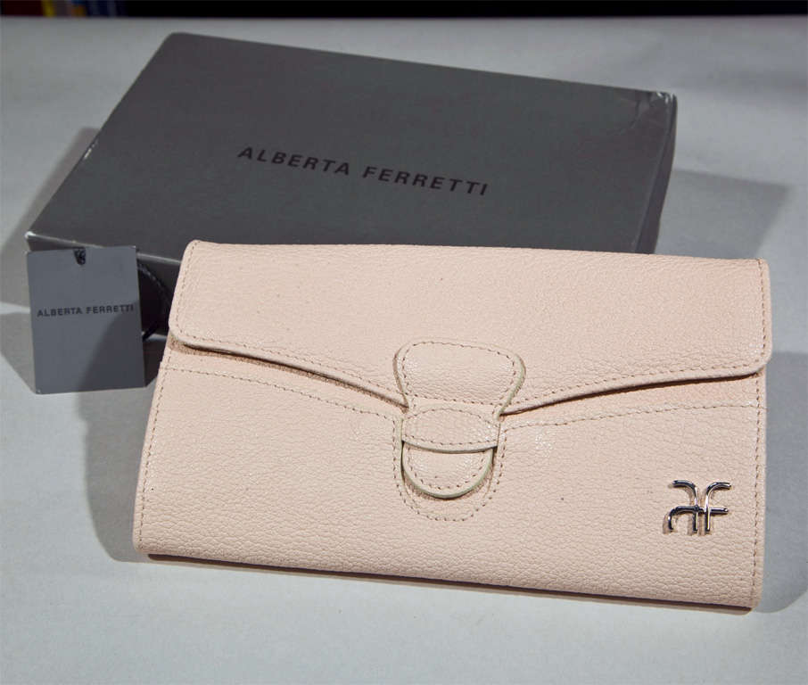 funkyfinders is pleased to present this beautiful pebbled leather, pretty-in-pale-pink clutch wallet from the house of alberta ferretti. a refined silver tone logo adorns the front in rather discreet fashion. 12 compartments are ready to house your