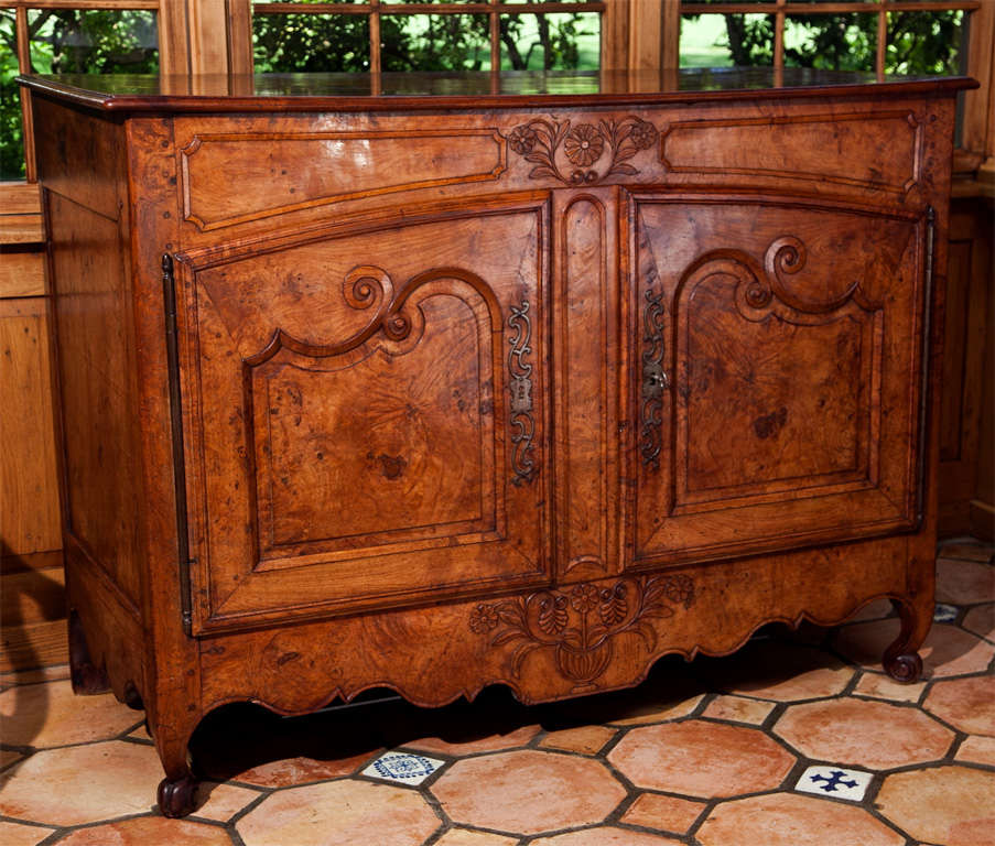 The rich patina of the burled elm and the fine carving combine to form a buffet of stunning appearance and demeanor. Aside from the overall attractive appearance, what sets this buffet apart from its contemporaries is the fact that rarely are case