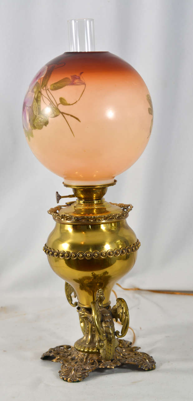 Mid 1800's, electrified Banquet Table Lamp, with rare Gargoyles on each side of the base, and an original hand painted glass shade at the top.  (Can be wired to carry a silk lamp shade).