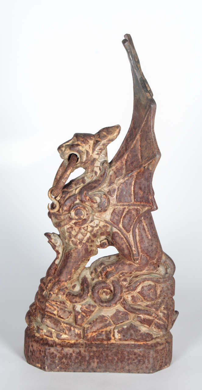 American, 19th century, cast iron hitching posts depicting winged griffins. Each griffin is clutching serpents in their talons, and are mounted with a ring through their mouths. Beautiful patina and excellent web detailing on wings.