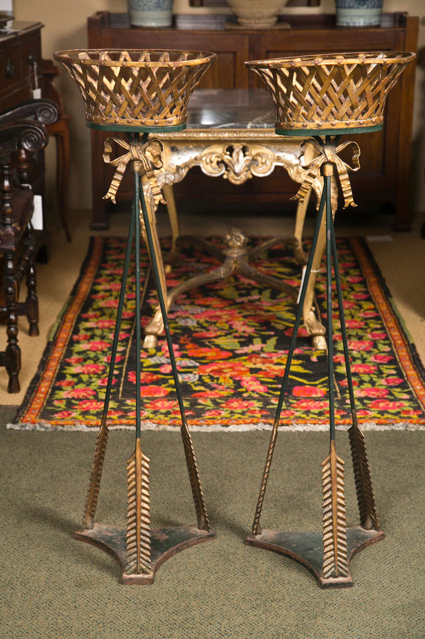 A pair of French, neoclassical basket-form jardinieres with ribbon decoration and an arrow form base.