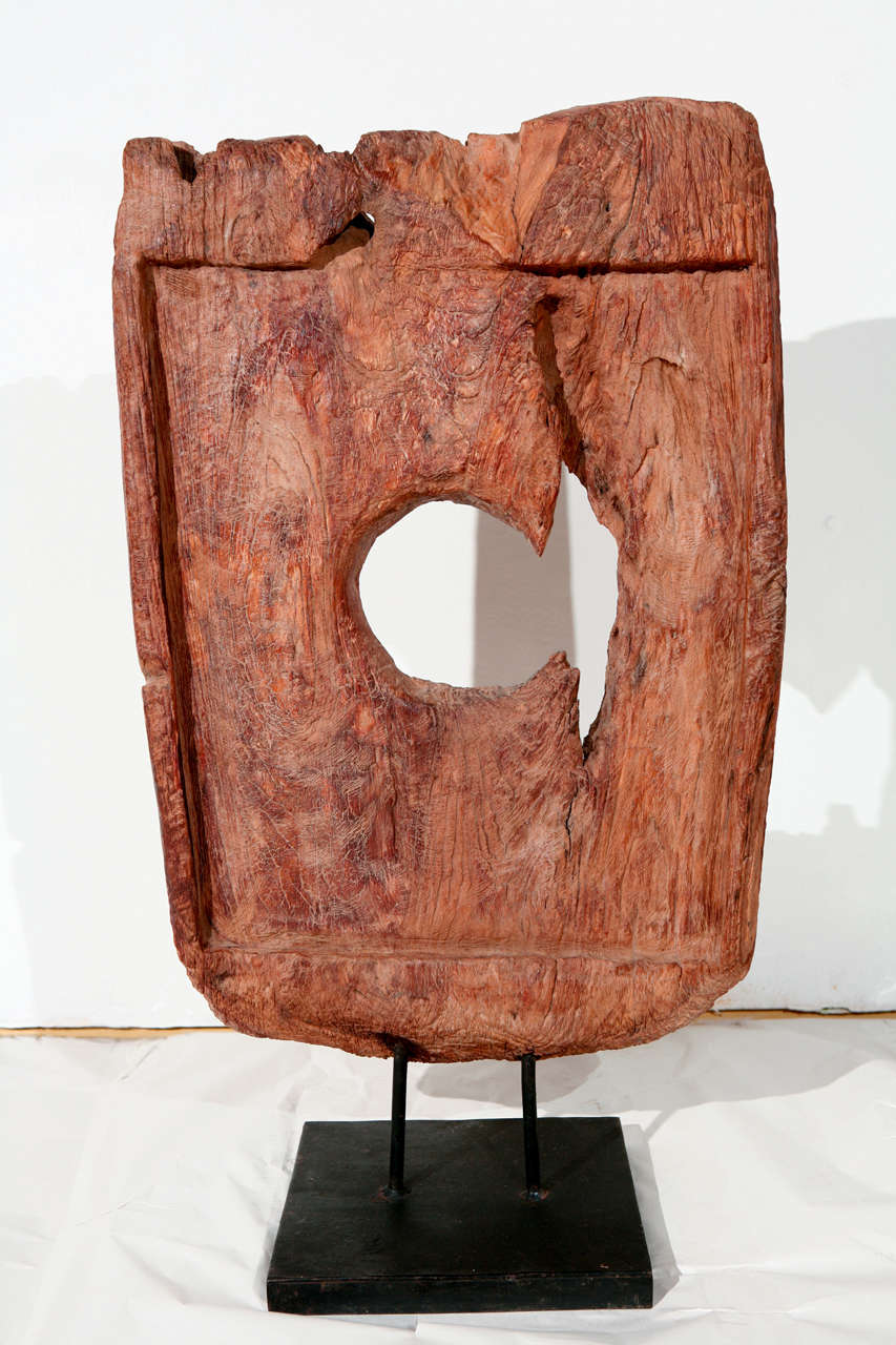 Une sculpture asiatique vintage en bois taillé à la main sur un socle en fer. 