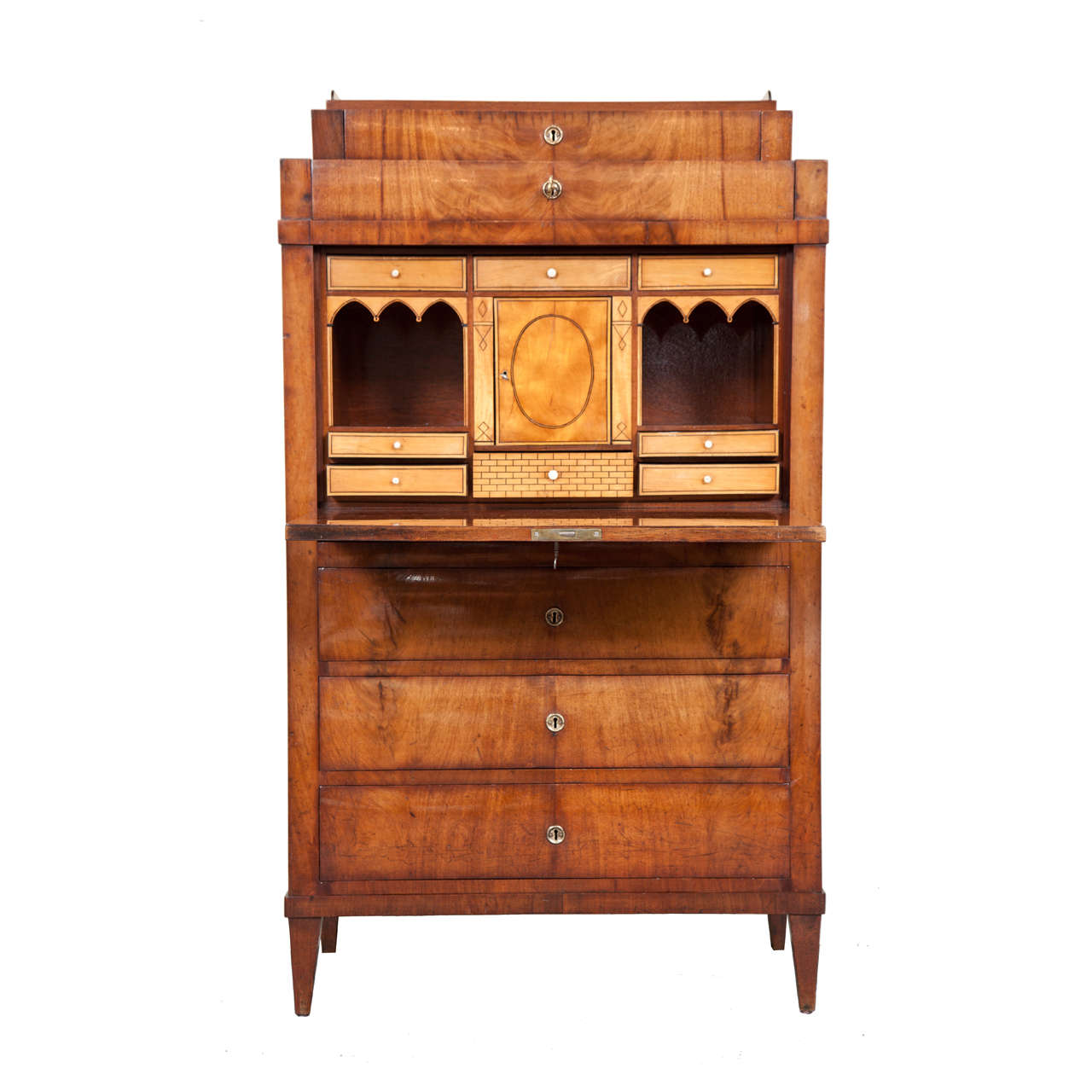 A Danish Empire mahogany and fruitwood inlaid fall-front secretaire, Early 19th Century, the rectangular galleried top above two stepped drawers, the drop front writing surface opening to an architecturally fitted interior with various drawers and a