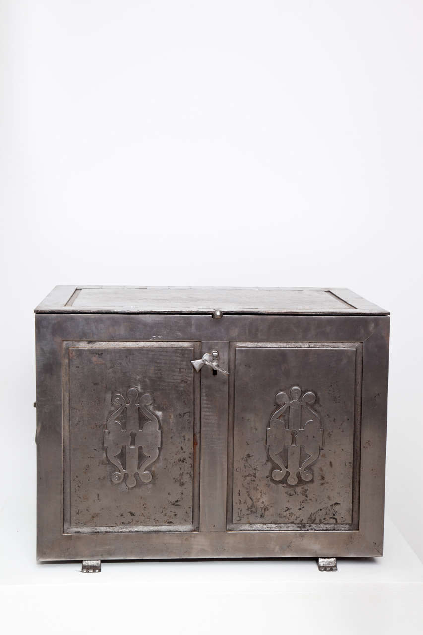 A Danish steel safe, mid-19th Century, the rectangular paneled hinged top above a rectangular paneled body with applied scrolled steel carvings, raised on stylized paw feet.