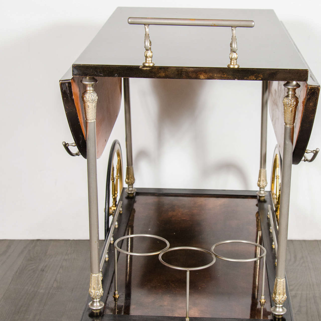 Stunning and luxe lacquered goat skin bar or serving cart by Aldo Tura.  This cart features two-tiers that are supported by stylized column supports.  The bottom tier has an inset center that has a surround of brass rails and a three bottle holder. 