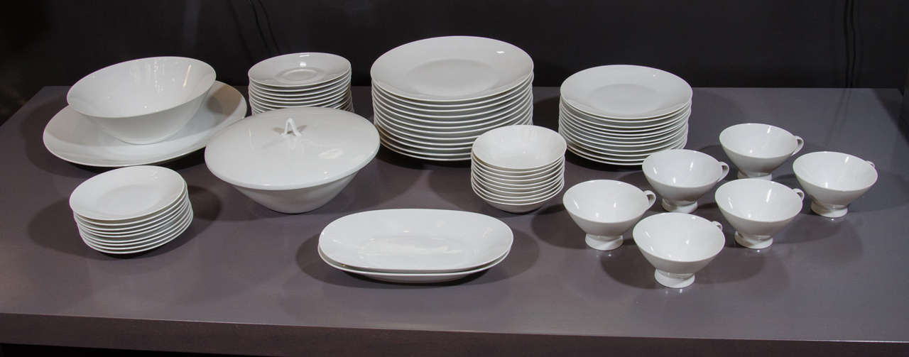 Modernist set of white porcelain china includes 77 pieces, and service for 12. The pieces have elegant tapered details and streamlined forms. The set includes 12 dinner plates, 12 salad plates, 12 bread plates, 12 dessert bowls, 12 coffee cups, 12
