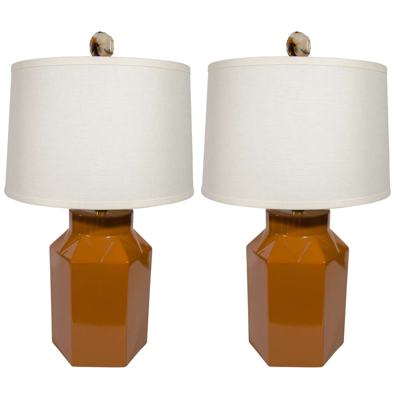 Pair of midcentury ceramic lamps with modernist hexagon forms. The lamps have a striking glazed finish in cognac. They feature faceted triangular details along the tops, reminiscent of Machine Age era design. The lamps have brass stem fittings, and