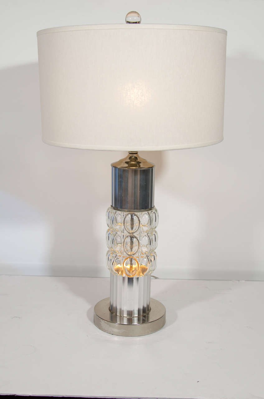 Machine Age lamp in brushed chrome metal with stylized fluted stem details and a molded glass center with modernist bubble design.  The glass center illuminates and has its own light setting in addition to the top main light.  The lamps features