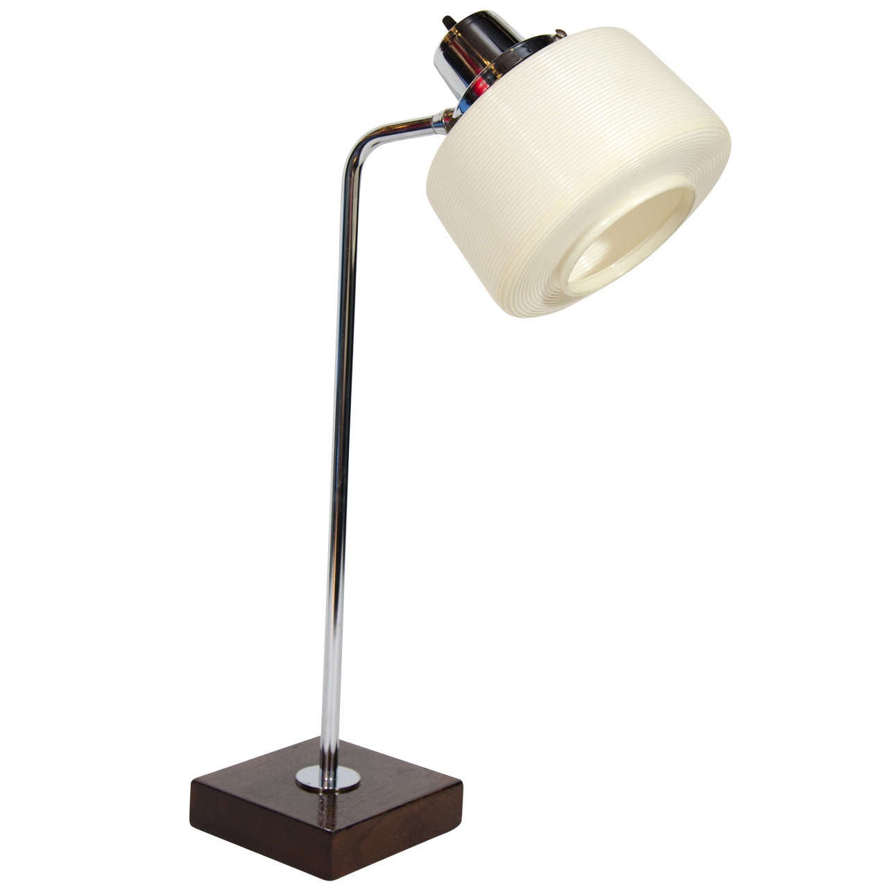 Vintage modernist desk or table lamp with stylized arched stem in polished chrome. The lamp features a square walnut wood stained block base, and a circular rotaflex lampshade with horizontal ribbed details that Heifetz is known for.  The lamp