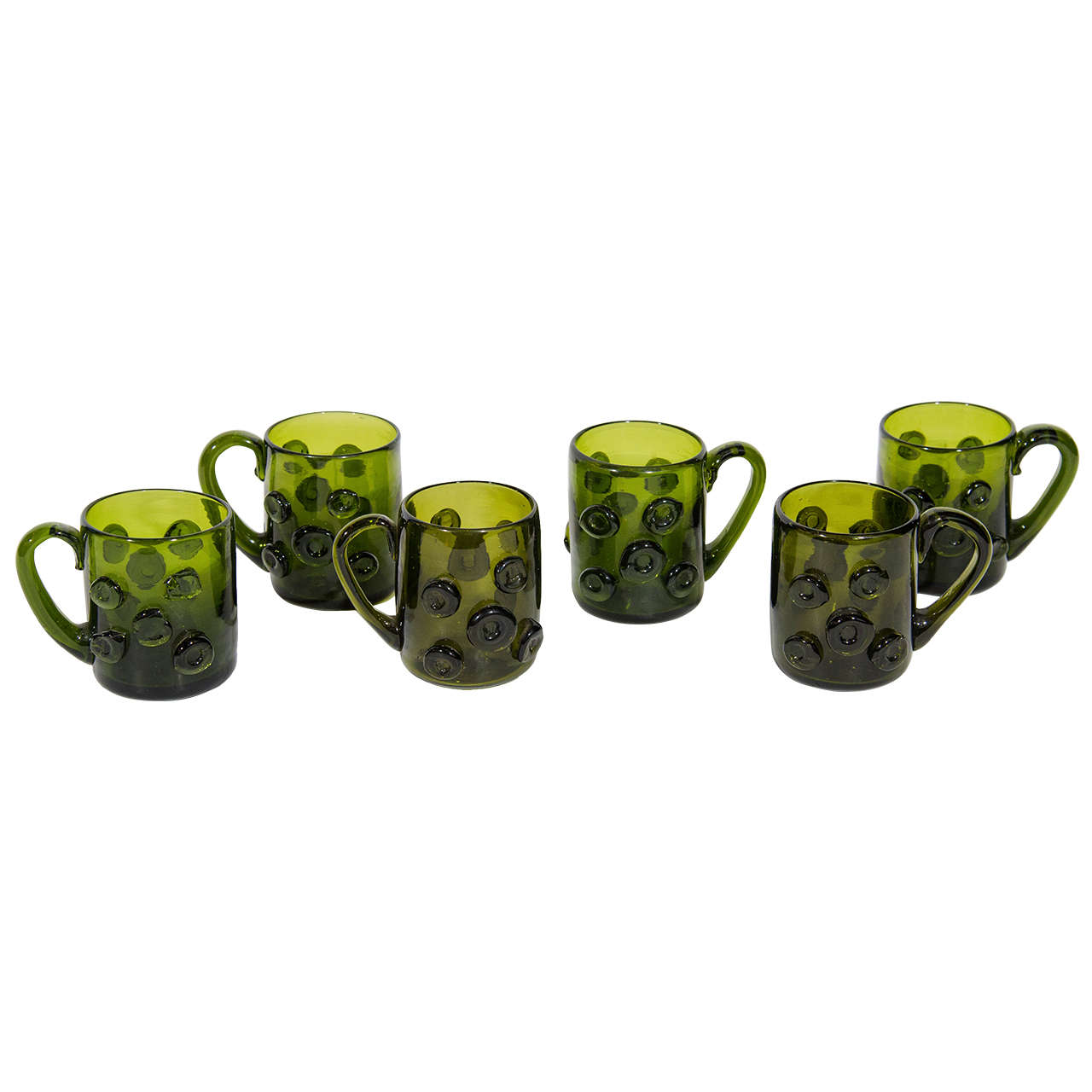 Set of six charming handblown glass mugs perfect as espresso cups or liqueur glasses. The glasses have a beautiful emerald green tone and feature circular prunts along the exterior, as well as fine sculpted glass handles.