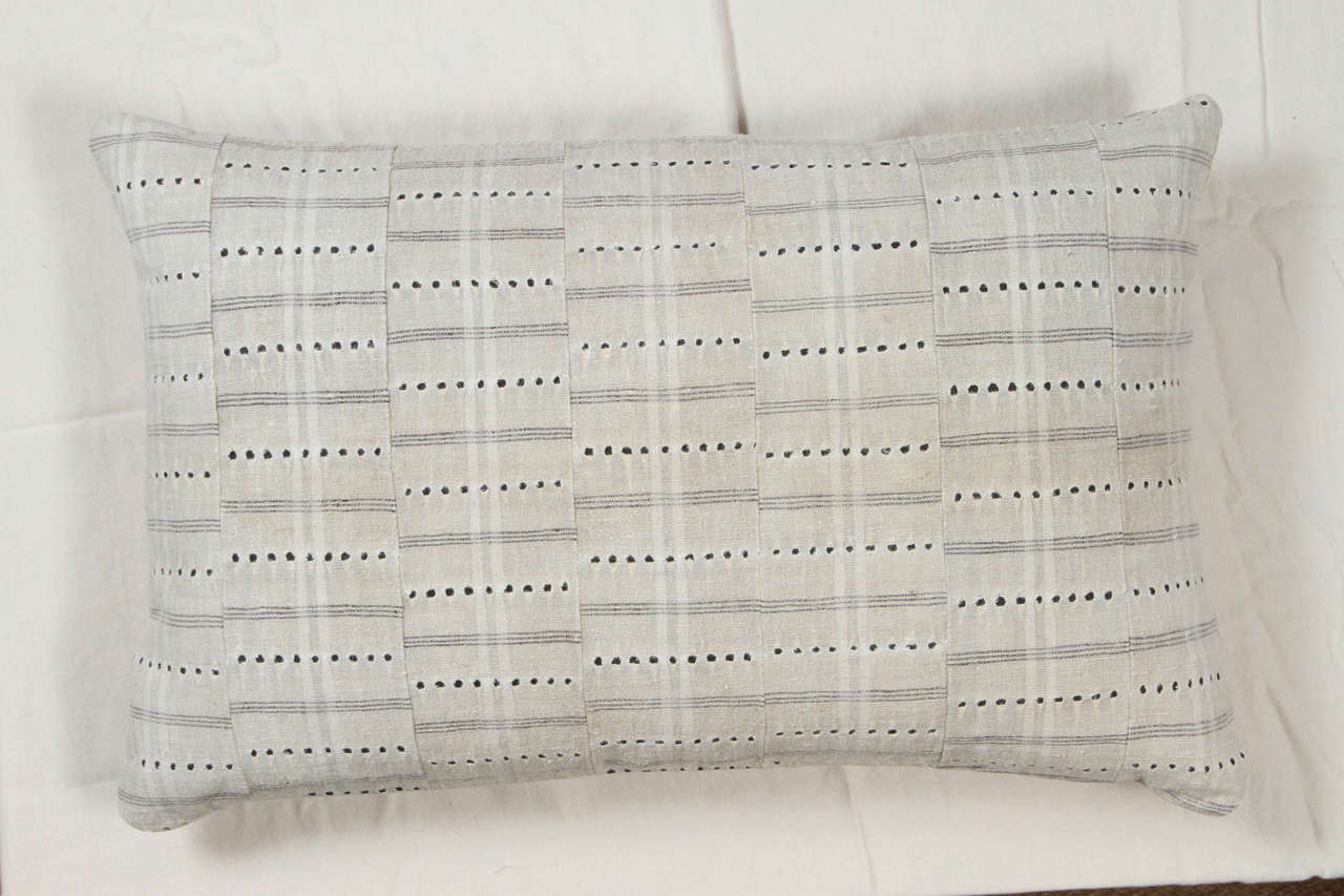 Vintage textile from Ashanti tribal people of Ghana. Fabric handwoven in narrow strips sewn together with pull work details. White fabric backing seen through the pull circles. Pillow back is natural linen. Invisible zipper. Feather and down fill.