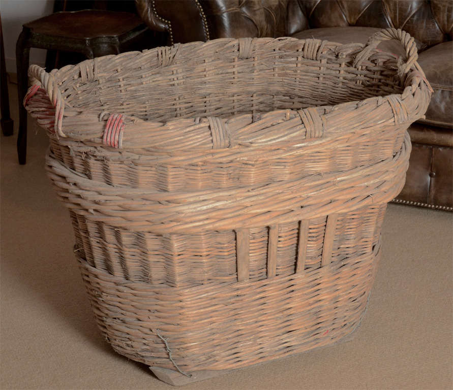 A large French wicker basket from the 1920's with twisted wicker carrying handles and painted OR letters, probably identifying it from the OR vineyard.  Two more available from a different vineyard. Price is for one.