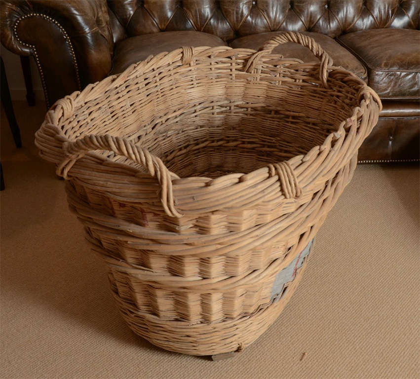 A large French wicker basket from the 1920's with twisted wicker carrying handles and painted PD letters.