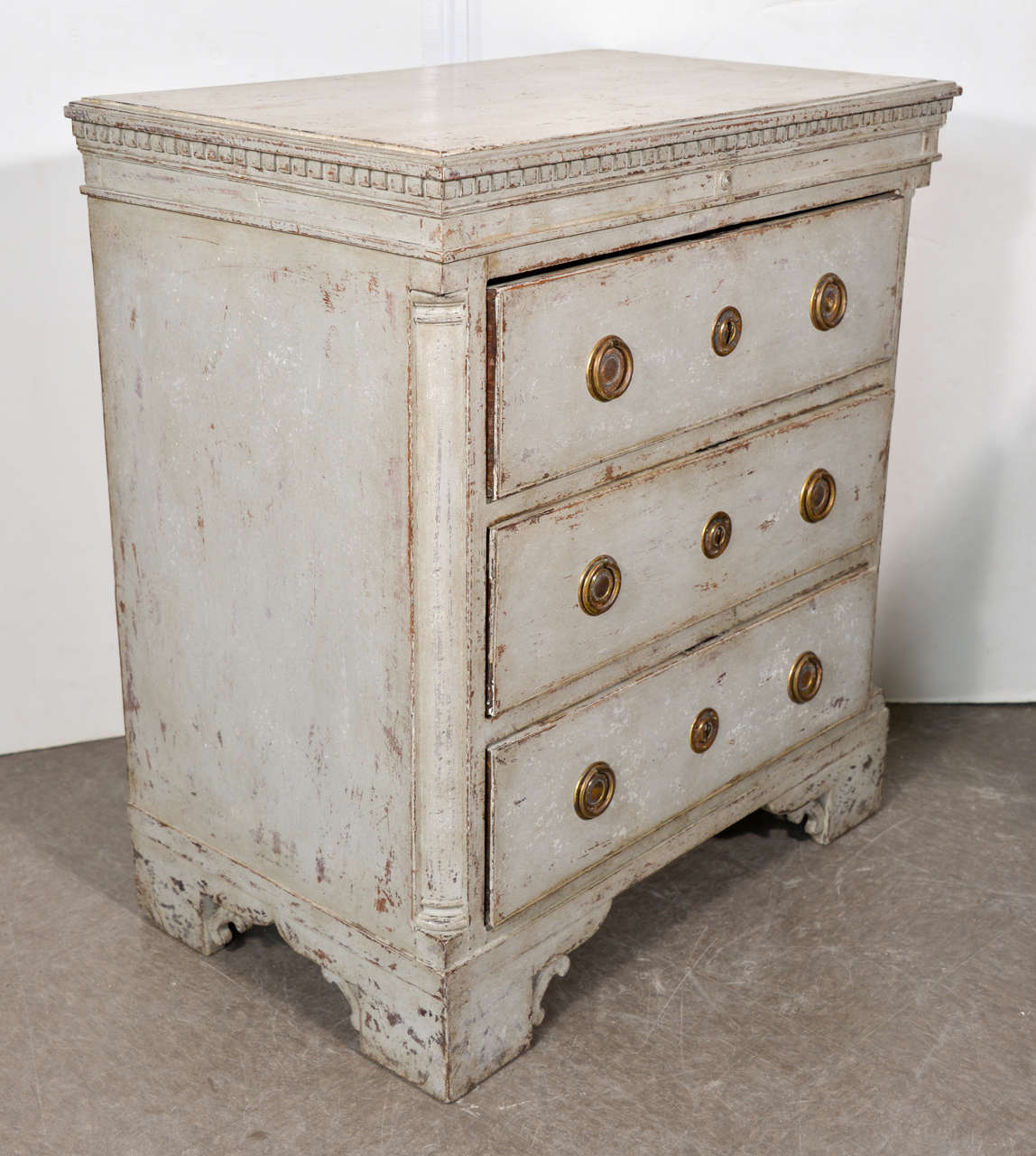 Swedish three-drawer commode in a desirable small style. Blue-gray paint. Intricate decorative details (brackets at the feat), circa 1790.