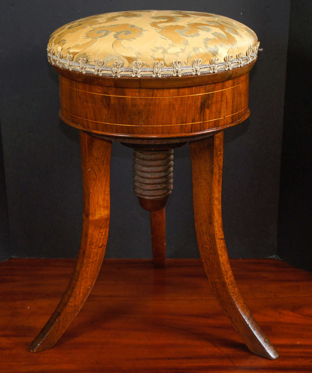 This lovely stool made of fruitwood and walnut circa 1820s was designed as a piano stool with adjustable heights possible by means of the large carved wood screw drive built into the base but can be used as a regular stool for additional seating in