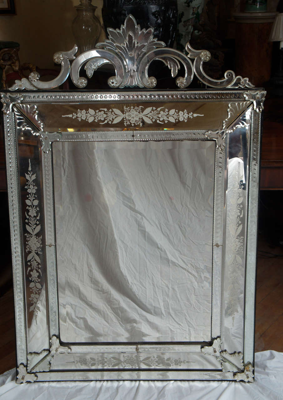 This finely crafted Baroque style mirror is composed of a deeply beveled mirror plate surrounded by faceted and bevel cut mirror plate frames  each side centered on the finest  engraved mirror panels all attached with bevel cut jewels, lozenges