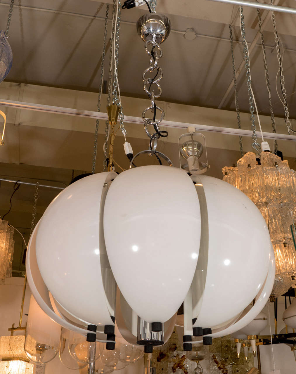 A very cool Italian, 1970s Mod design pendant light in chromed iron, white enamel metal and Perspex (Lucite). The body, chain and ceiling canopy are all chromed iron. Eight wedge shapes house a single light and are suspended away from the central