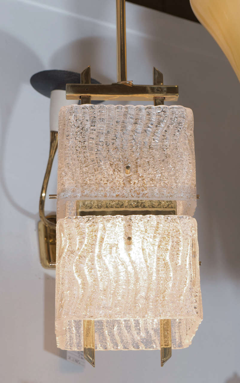 A lovely 1950s modern Italian pendant light in the manner of lighting manufacturer Stilnovo. Supports, screws and rod in brass with original black enamel ceiling canopy. Two independent square hand formed glass shades house a single standard light