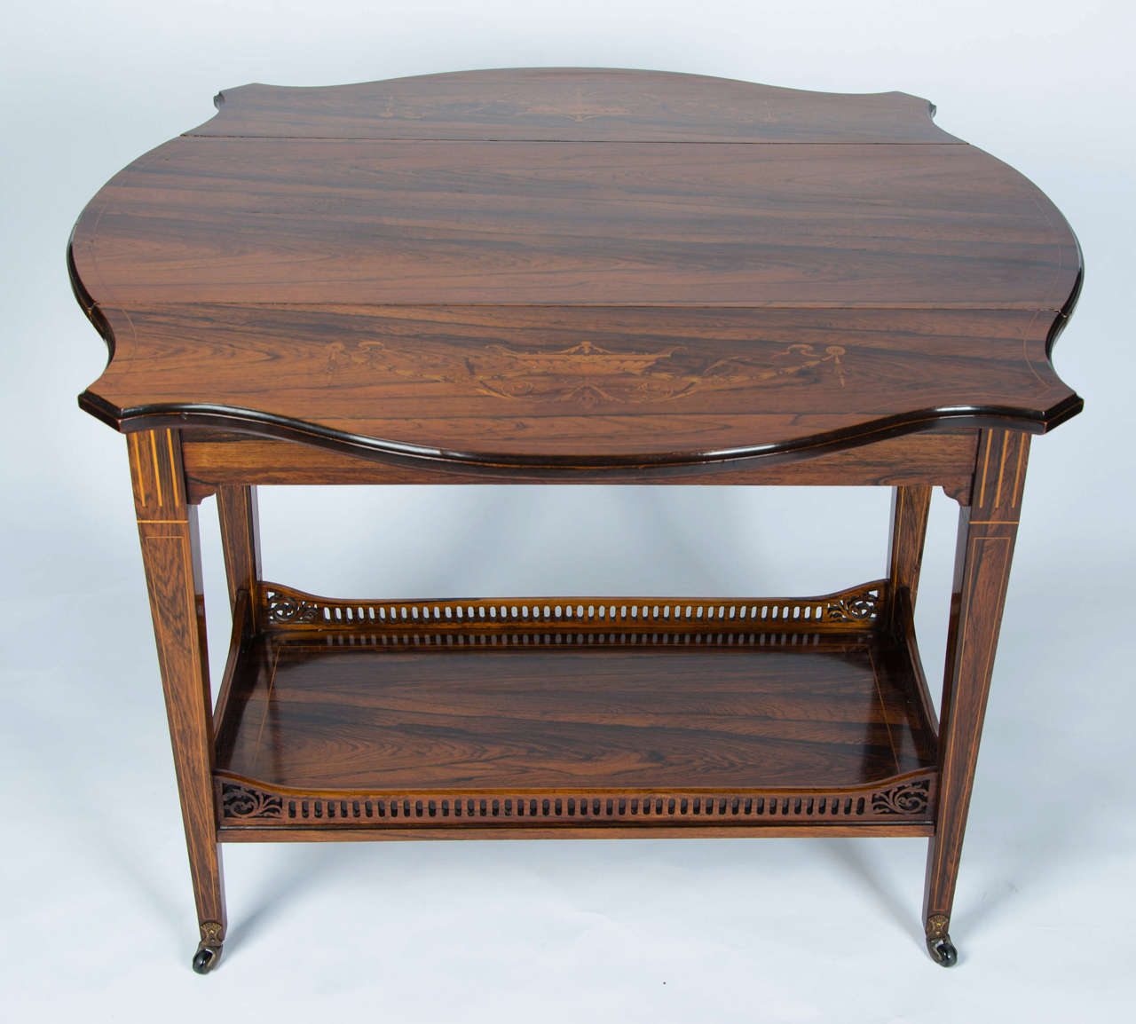 A fine example of an Edwardian marquetry drop-leaf table with two end drawers and galleried lower tier.