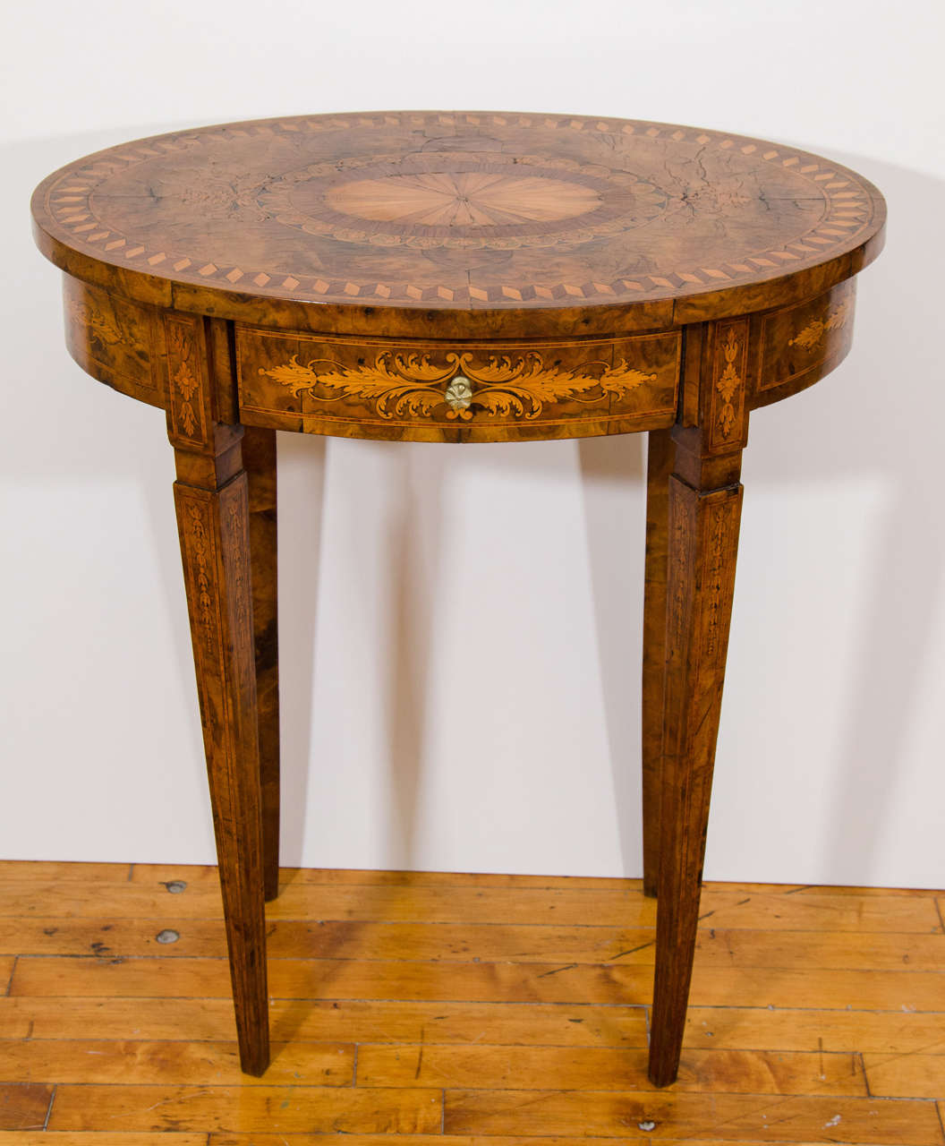An exquisite early 19th century marquetry inlaid English side or center table.

Good condition with age appropriate wear.  Some cracks to the top.