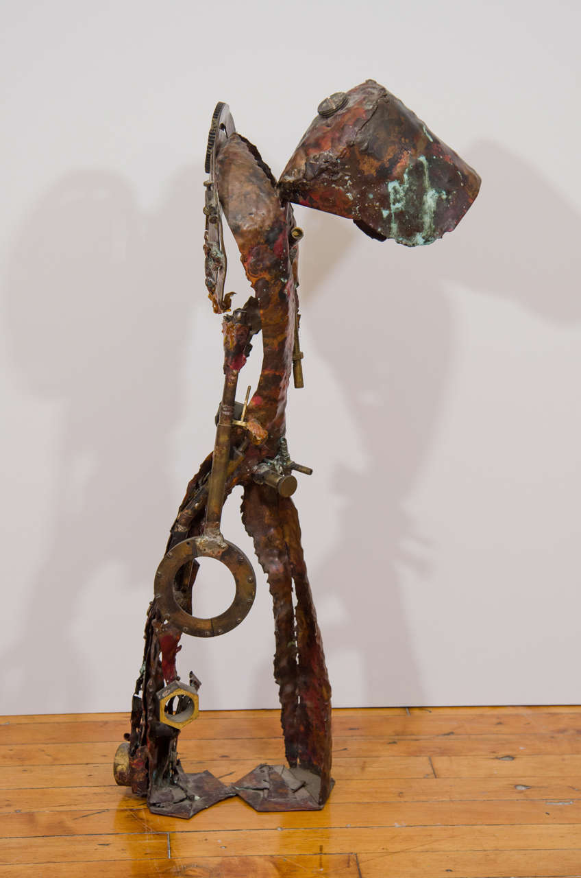 A Brutalist male figural sculpture made of copper parts like bolts, nuts, and a lock.

Vintage condition with age appropriate patina.

Reduced from:  $2,200