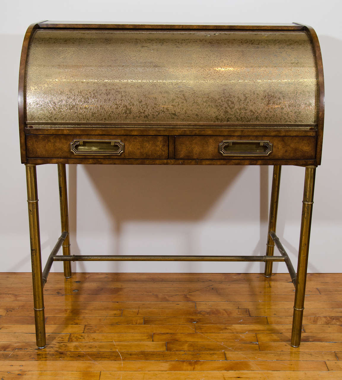 Mastercraft Amboyna burl wood and etched brass roll top desk with brass bamboo legs. The piece has two drawers, several interior compartments and a leather writing space. 

 