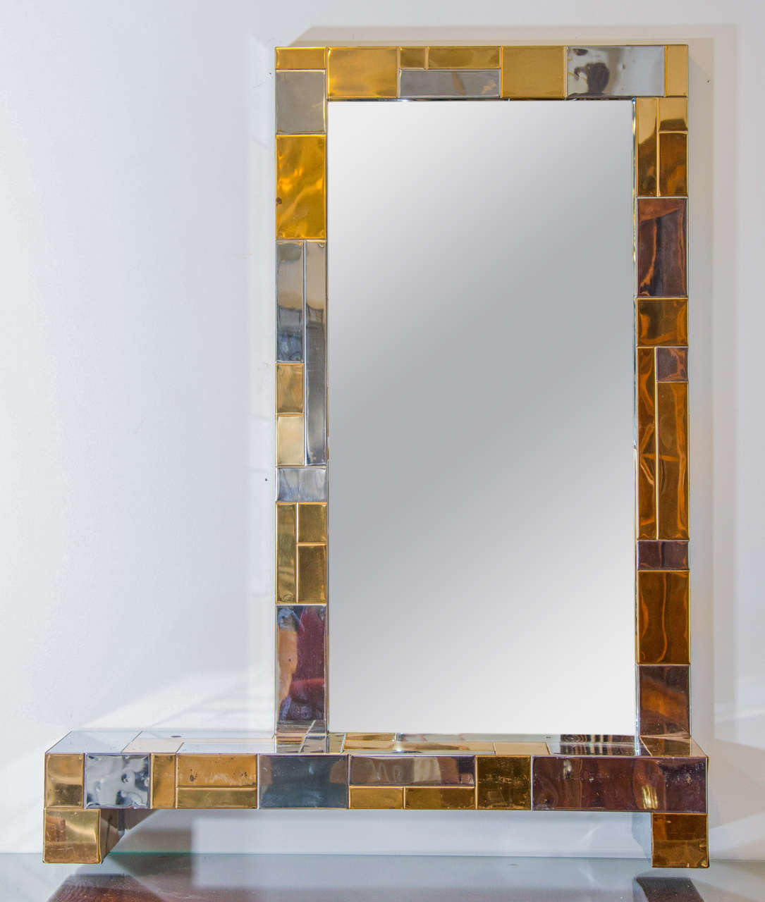 A vintage Paul Evans mirror and shelf in chrome and brass patchwork.

Vintage condition with age appropriate wear.  There has been some oxidation to  the patchwork.

Dimensions: Shelf base: 36