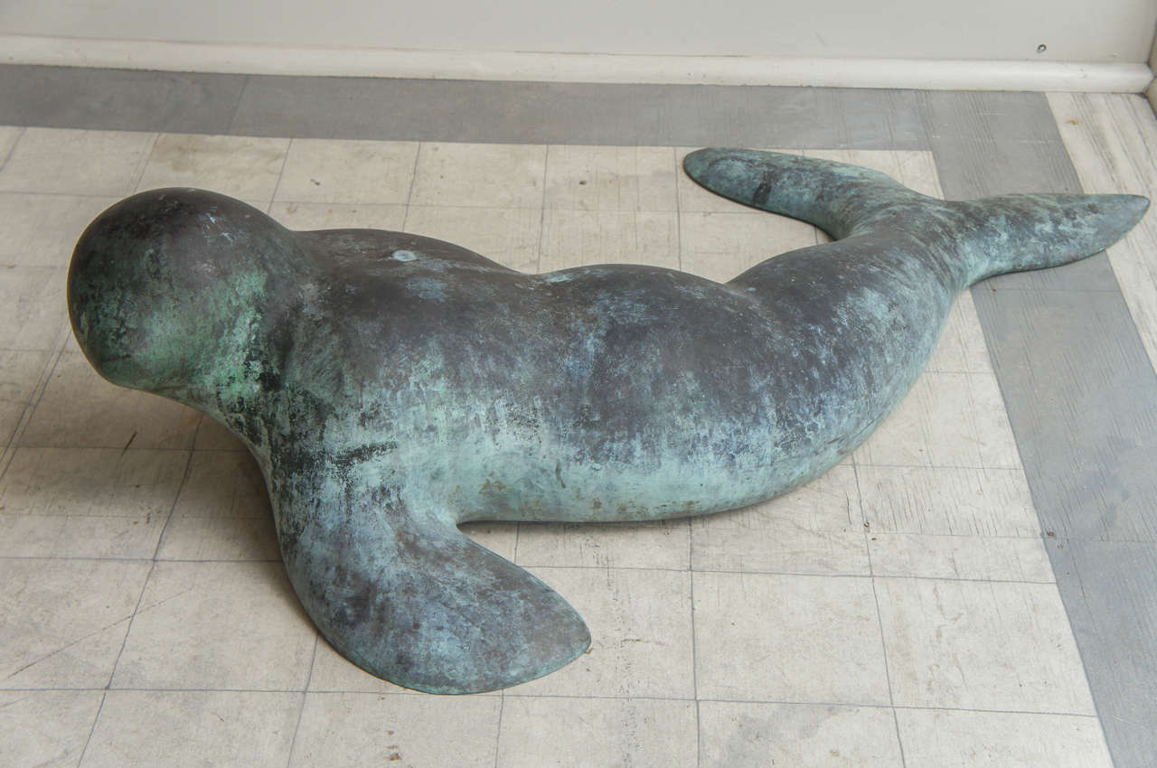 Sensuous sculpture of a seal, inuit influenced, hollow cast bronze, tabs for attachment, superb verdigris surface, signed 