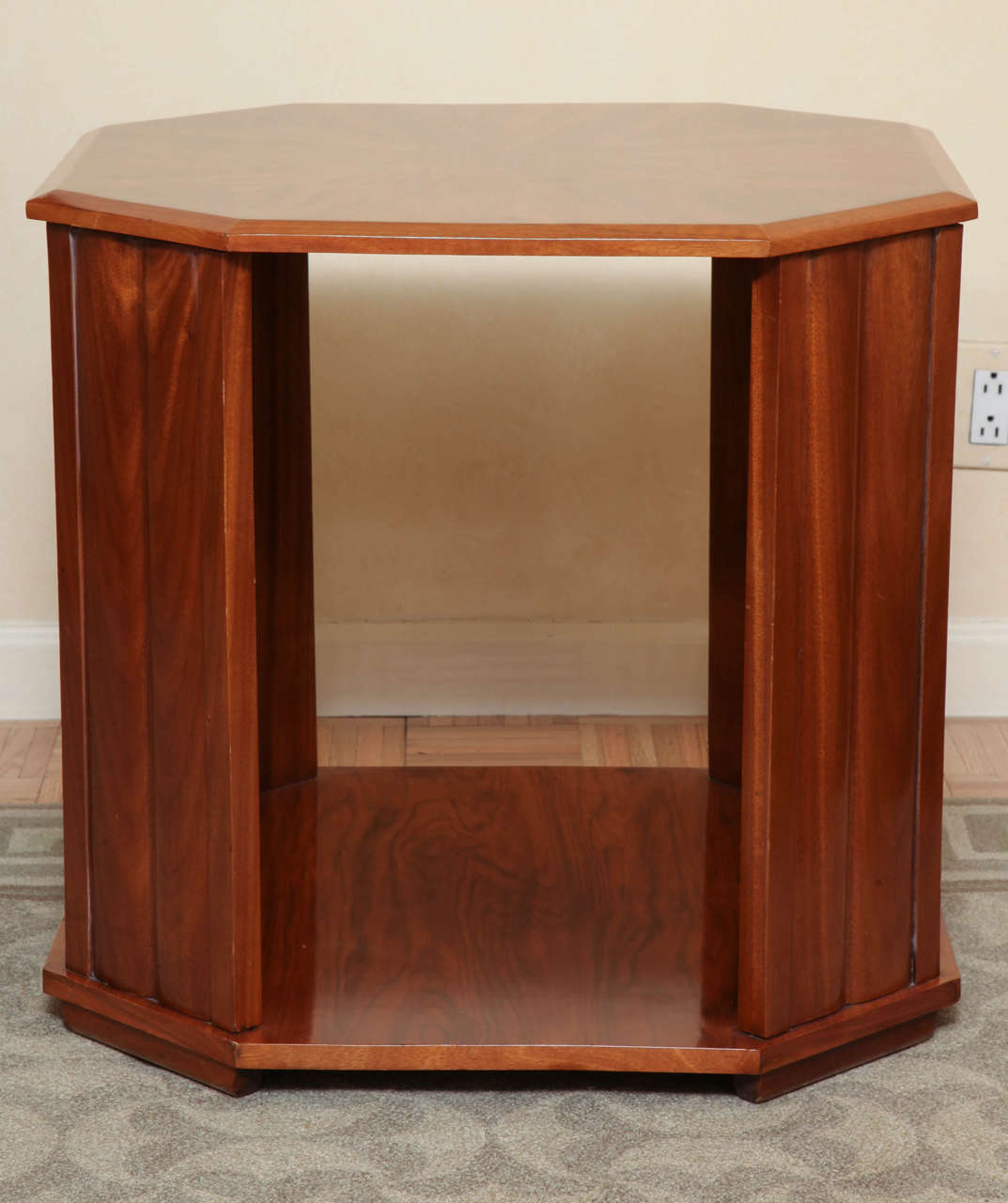The octagonal top with radiating parquetry inlay; raised on four canted paneled supports joined by a platform stretcher on block feet. Lovely faded color and lively timber.