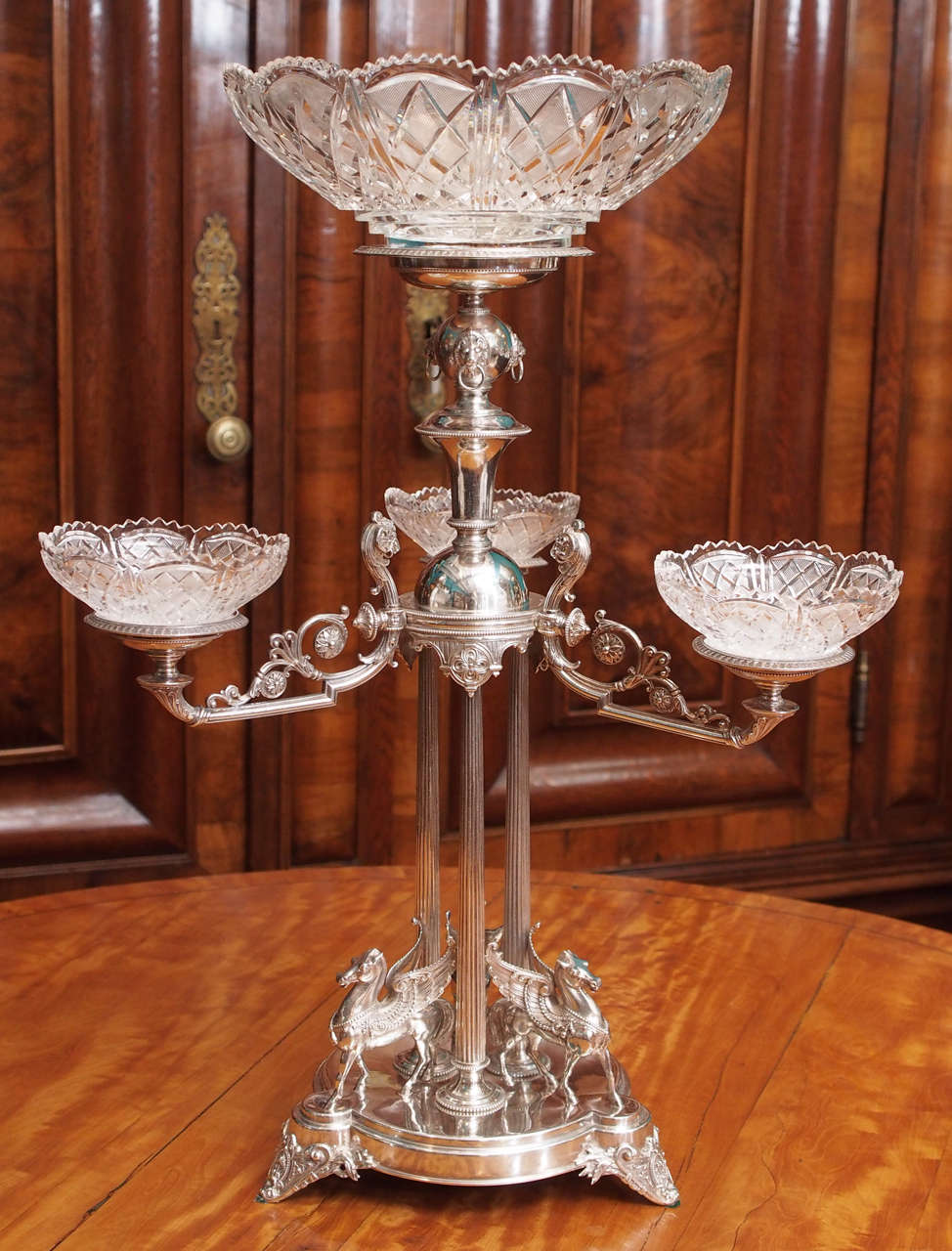 Extravagant and exceptional late 19th century English plated silver three arm epergne in the Elkington taste, with classical ornamentation, including rams, lions and winged horses, four cut crystal bowls, circa 1875.