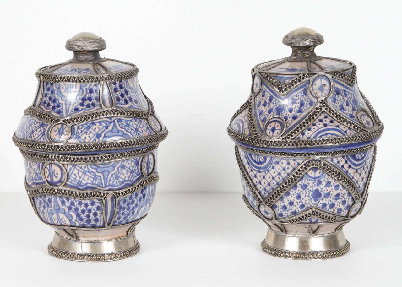 Pair of Moroccan antique urns with lid. Blue and white ceramic handcrafted in Morocco and adorned with silver filigree.
The two urns are not identical.