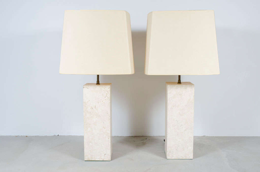 A monumental pair of travertine table lamps in an elegant square column-form. American, circa 1990.