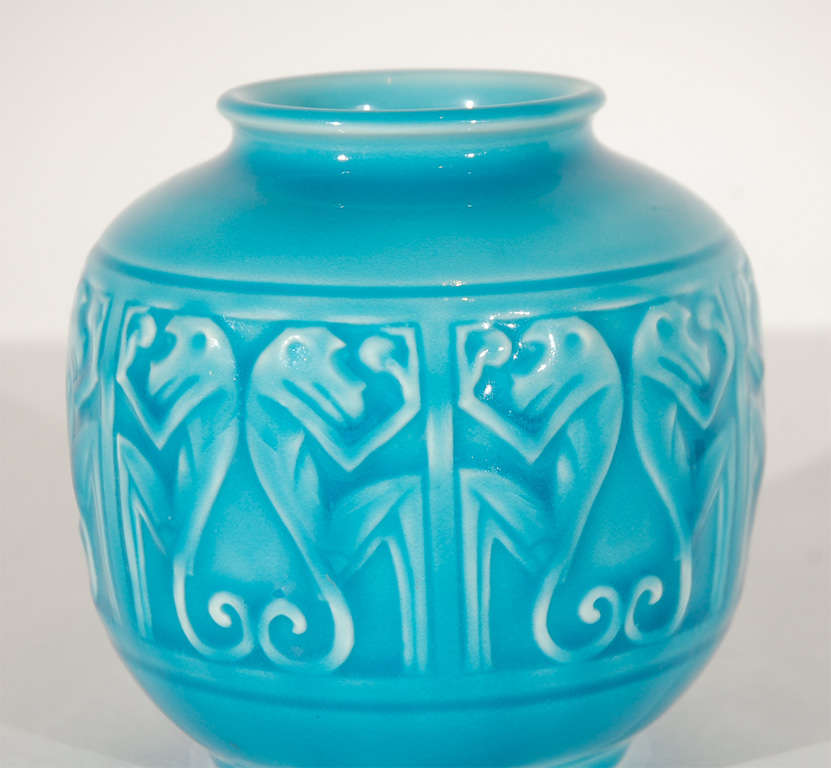 A beautiful Rookwood vase featuring six pairs of framed stylized monkeys and glazed in a brilliant turquoise blue. Stamped with the Rookwood logo, date and model # on the bottom (see Image 5).