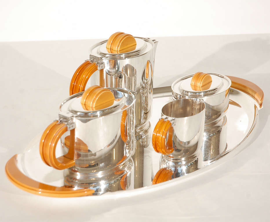 This five-piece silver plate Streamline Moderne style Coffee & Tea Service by F.W. Quist includes a coffee pot, teapot, lidded sugar bowl, and cream pitcher on a tray. All of the pieces have Bakelite handles. Dimensions given below are for the tray.
