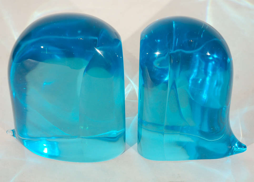 A striking pair of blue glass bookends with little tails. Dimensions given below are for the larger bookend. The smaller bookend measures 8.25