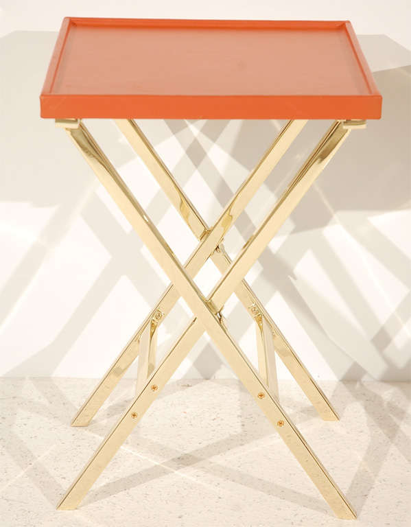 A chic pair of polished brass X-base side tables with rimmed leather-wrapped Hermes orange table tops. Tables are available individually for $3500 each.