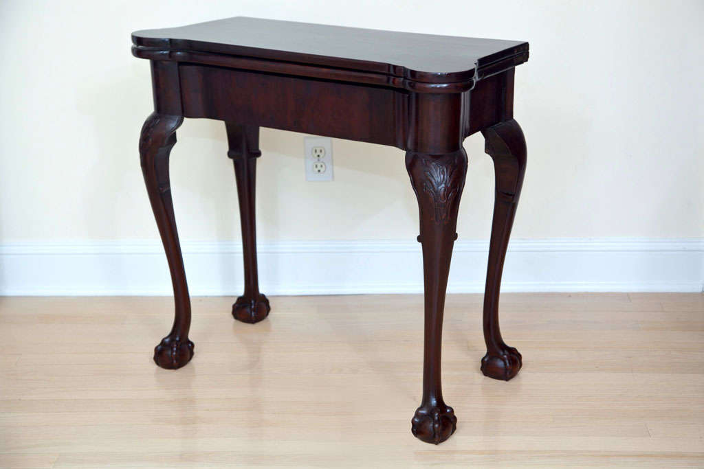 Lovely card table from the latter half of the 19th century. Folds in half.  Has Four chip pockets when open, one on each corner. Claw and ball feet.
