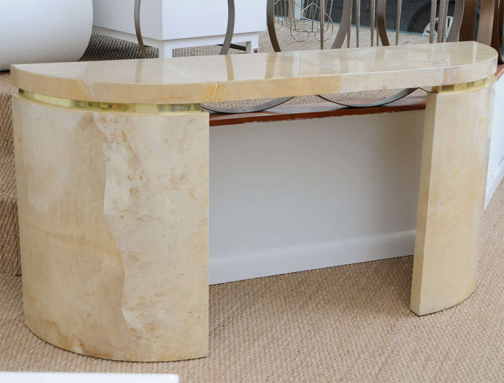 Console table fashioned of parchment colored lacquered goatskin. Two curved sides have brass banding just below the top surfaces which adds dimension and richness to this already elegant console table. Can be used as an entrance table, writing