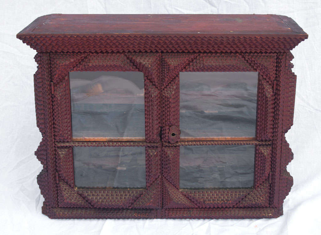 Great architectural form! Red-painted hanging or table-top cupboard with original glass and lock.  Lined with 19th century black and white lithographs.