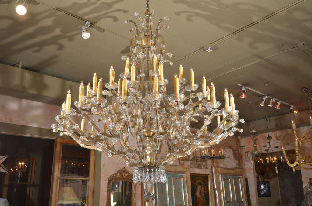 Large Italian Maria Theresa chandelier . Bronze arms covered in crystal and glass covers on the interior column.
