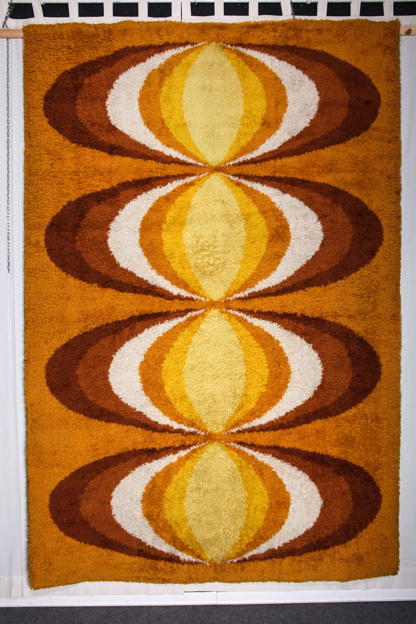 A powerfull and attractive rug. Biege field with round and wavering shapes, with a quite optical look, long hair.This original Dutch carpet of the 70's, with a thick hair and a 