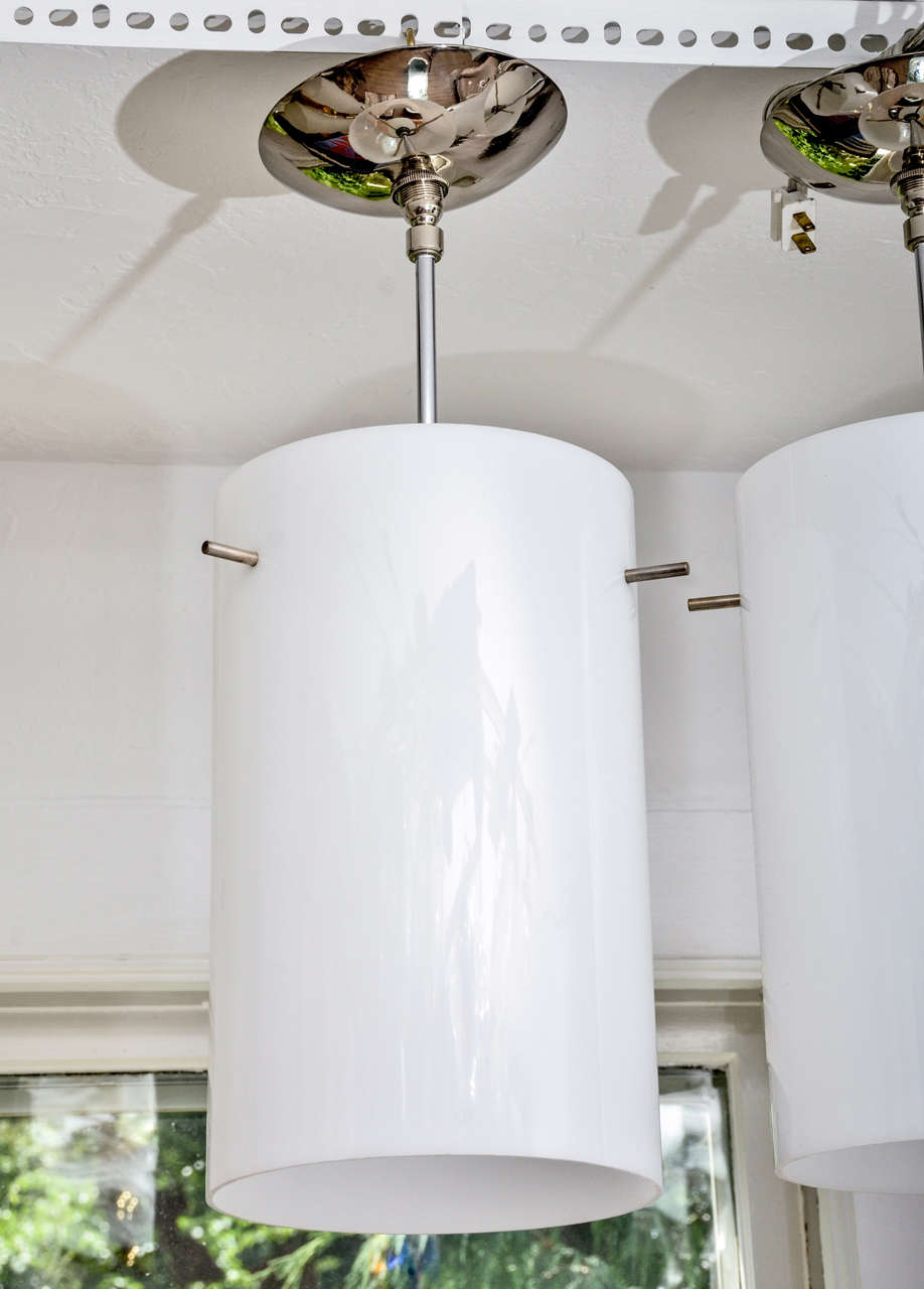 Pendente a tubo in plexi bianco con dettagli in nichel satinato.  Cablaggio di una singola lampadina standard. I tubi misurano 8
