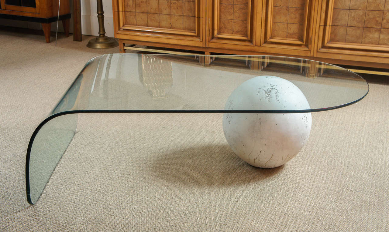 Here is a chic and elegant coffee table with a glass top and a plaster ball base.
The ball is not attached and the half inch thick glass top has a waterfall edge.