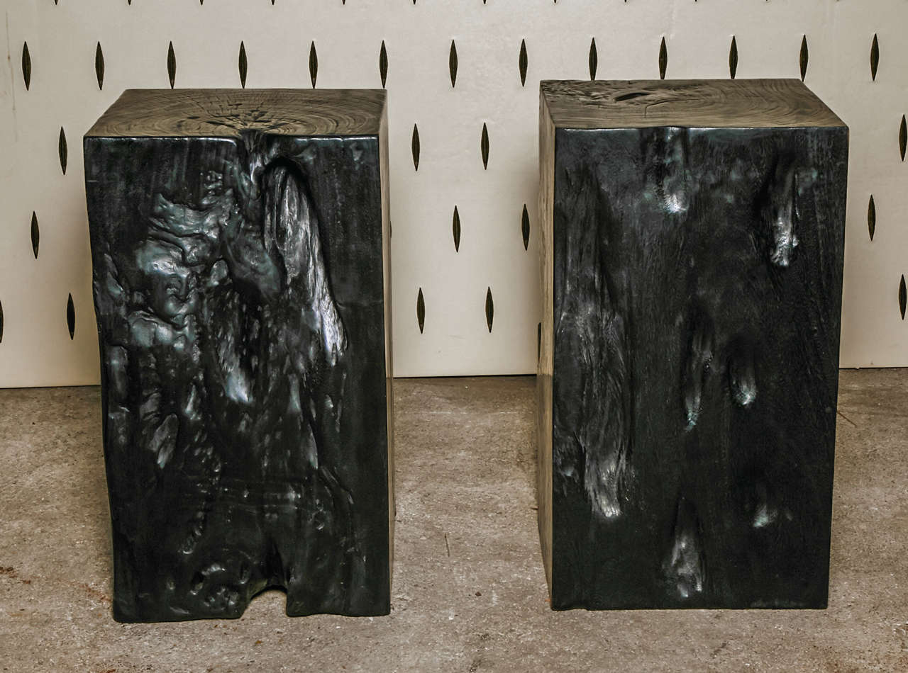 A pair of black azobe wood pedestals.