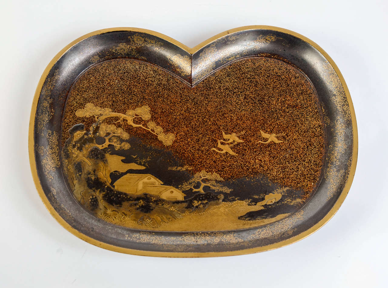 Small 19th century nashi-ji lacquer tray with a gilded and silvered hira maki-e lacquer decor of cranes flying over pavilions on water side under the pine trees.